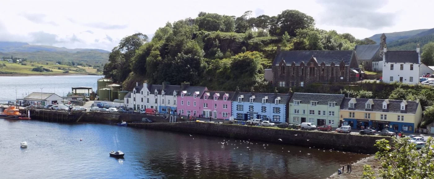 A line of brightly painted houses of different colours, along the harbour side in Portree on our Isle of Skye Tours from Inverness