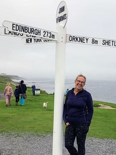 One of the Inverness Tour Guides, Amanda Sheppard our happy guide! At the John O Groats monument on one of our North Coast 500 tours!